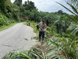 Bhabinkamtibmas bersama Warga Membersihkan Material di Lokasi Longsor di Bahu Jalan