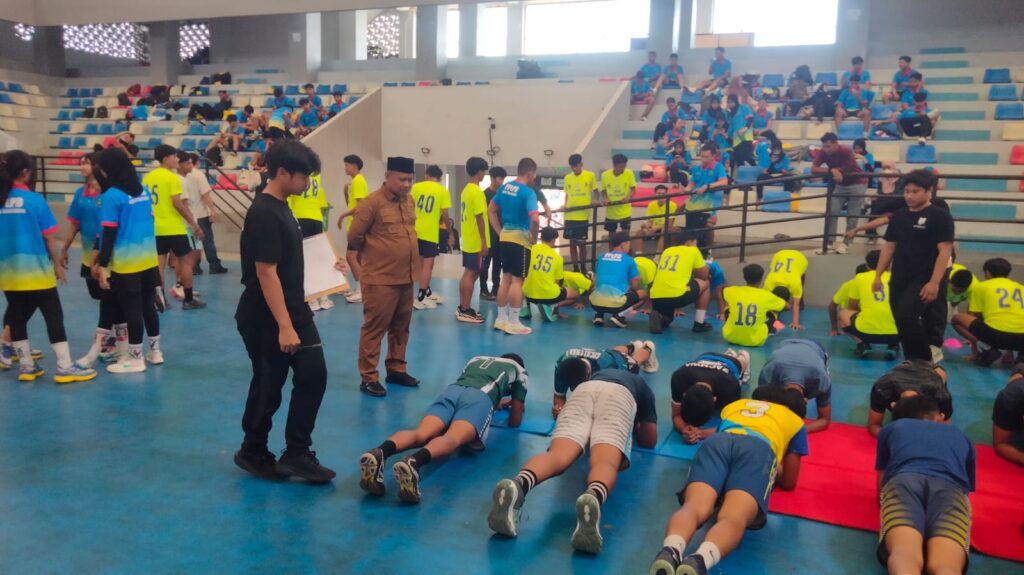 Kadispora Kota Tangerang Kaonang saat berinteraksi akrab dengan atlet pelajar di tengah kegiatan tes fisik GOR Nambo Jaya]